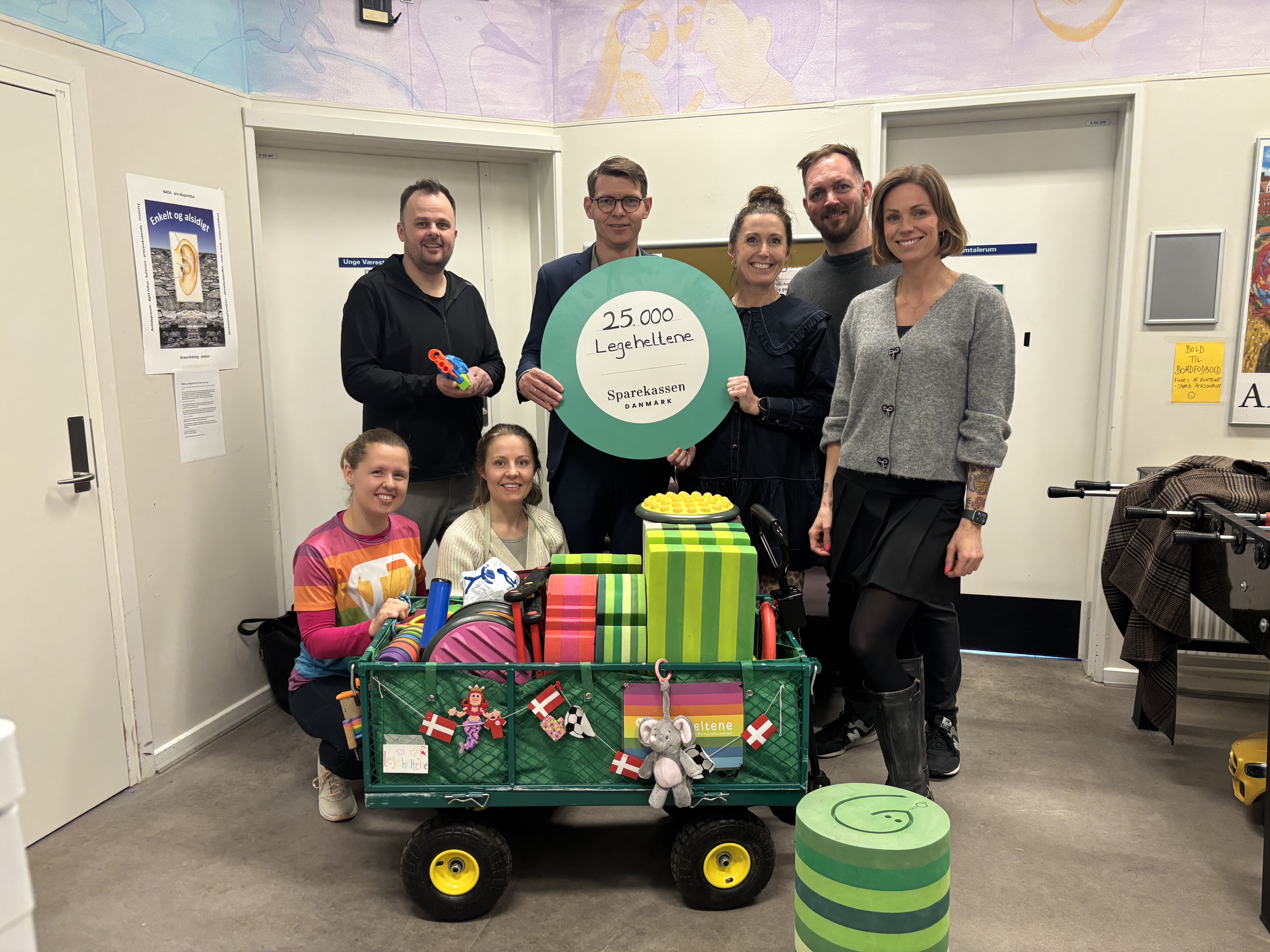 Henriette Madsen, Generalsekretær hos Legeheltene modtager gavechecken. På billedet ses bl.a. også Rene Christensen, Regionsdirektør hos Sparekassen Danmark samt holdkaptajn Lisbeth Østergaard